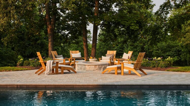 A serene pool area featuring lounge chairs and a cozy fire pit
